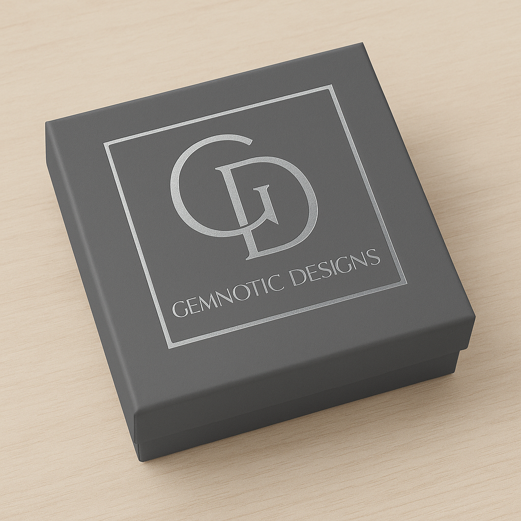 Gray jewelry box with Gemnotic Designs logo on a beige background