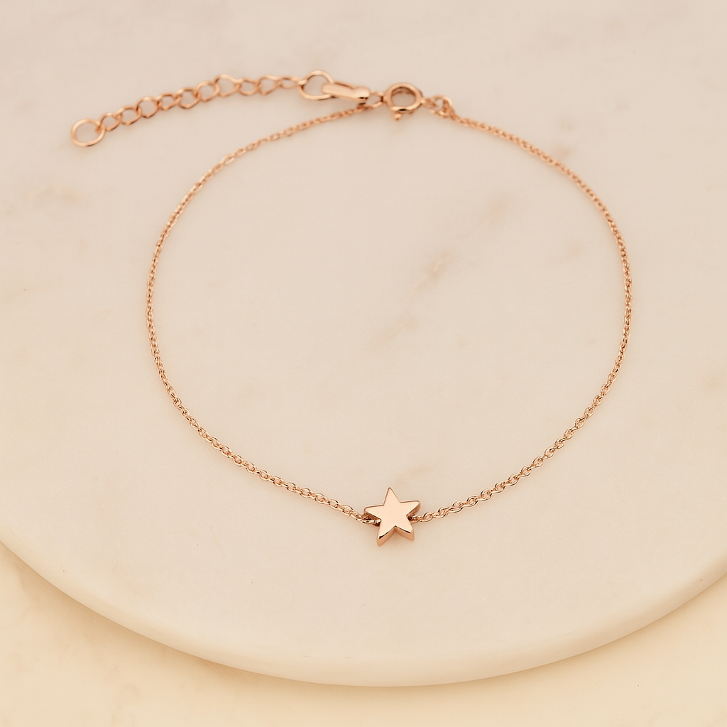 Rose gold bracelet with a star charm on a beige background