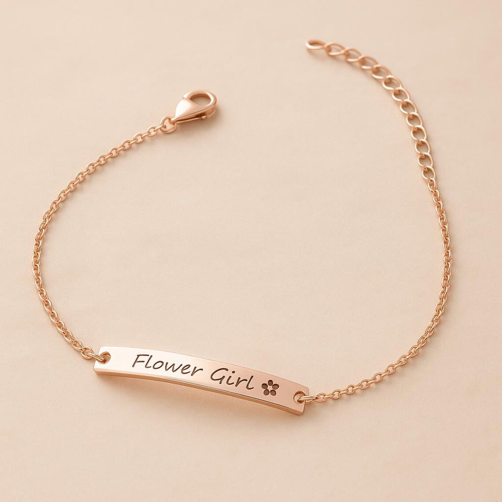 Rose gold bracelet with 'Flower Girl' engraving on a beige background