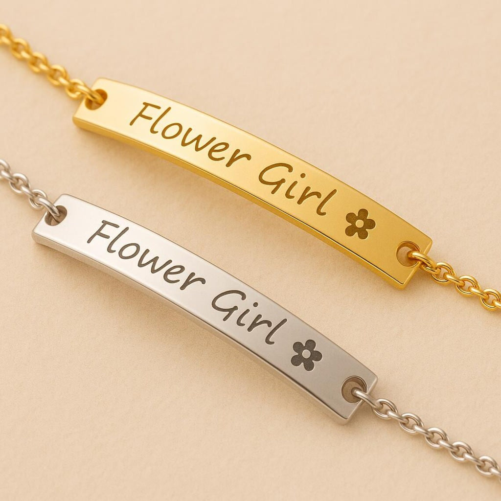 Two gold and silver bar necklaces with 'Flower Girl' engraving on a beige background